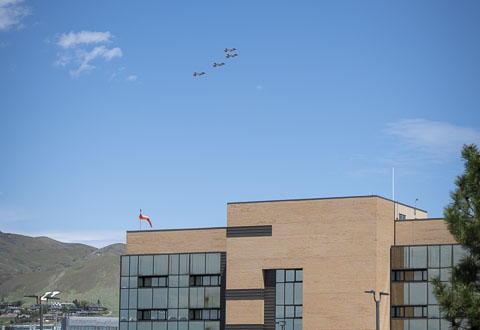 Four jets fly above a building