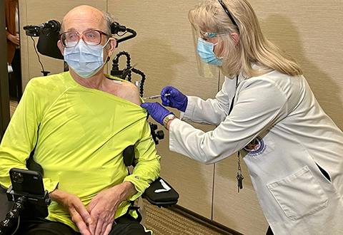 A male Veteran receives a COVID-19 vaccination